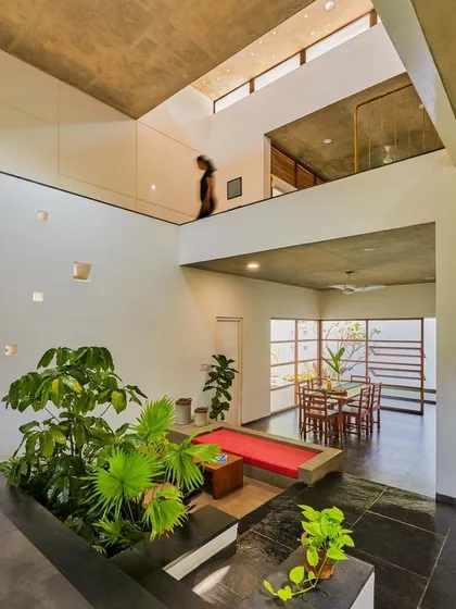 I believe greenery should be part of your home's architecture. Here, I designed a central indoor garden for a double-height living space, bringing in large plants to create a natural focal point that breathes life into the entire house.