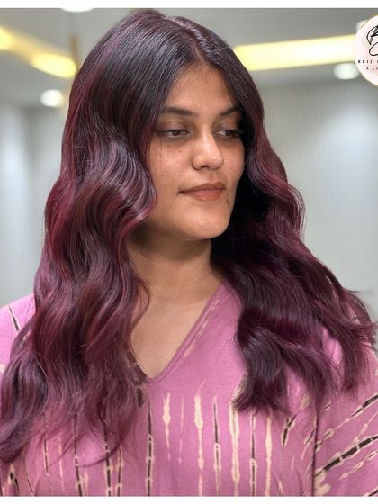 A confident client rocking her new velvety plum red hair, a truly striking and beautiful color.