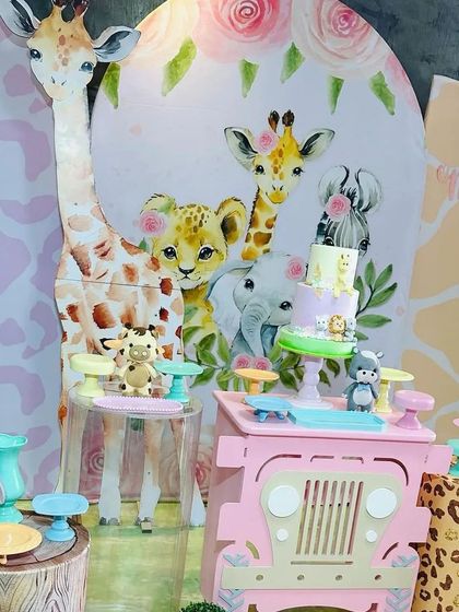 A close-up of the beautiful watercolor-style backdrop and the adorable cake from the pastel safari party.