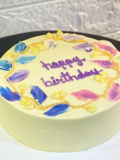 A beautiful minimalist cake decorated with delicate palette knife-painted flowers. This technique adds a touch of artistic flair to a simple design.