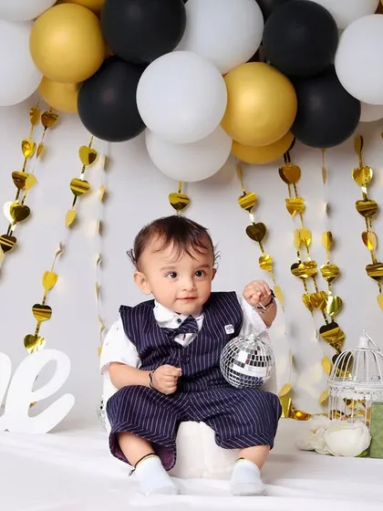 Another angle from the modern black and gold birthday shoot, showcasing the full setup with luxury-themed props and a happy one-year-old.