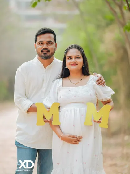 A sweet and simple outdoor portrait of a couple holding "MOM" letter props.
