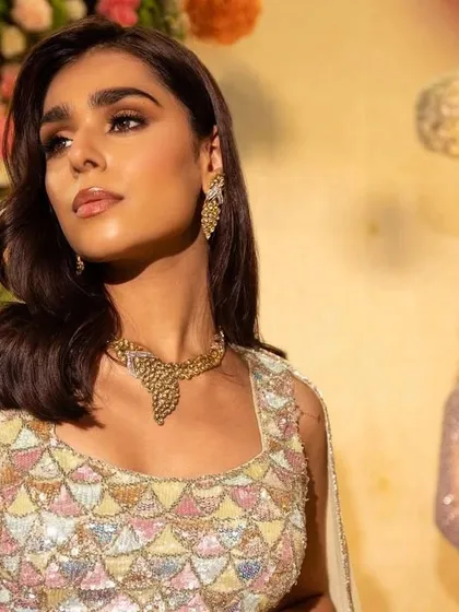 A close-up on the second model, highlighting her unique pastel and mirror-work blouse and gold jewellery.