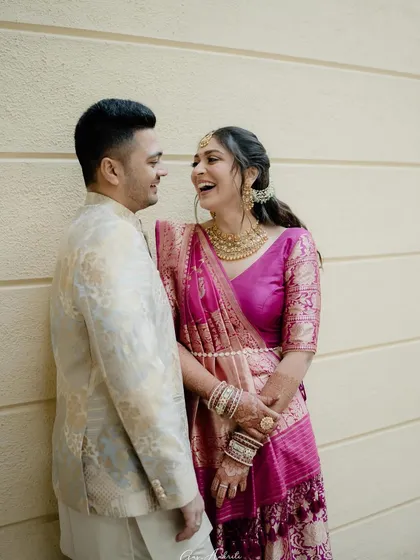 A candid moment of laughter with her partner. Her makeup looks natural and radiant, perfect for these happy, intimate moments.