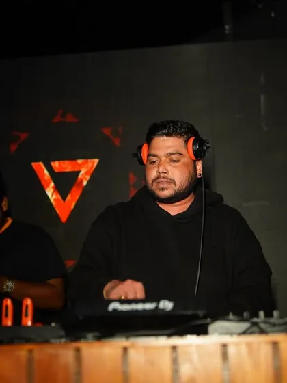 Another angle of me at the decks, with my headphones on, listening for the perfect moment to mix in the next song.