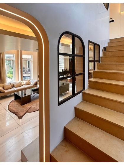 The arched entryway and staircase in the Palm Springs villa. The use of soft, integrated lighting emphasizes the graceful curves and creates a warm welcome.