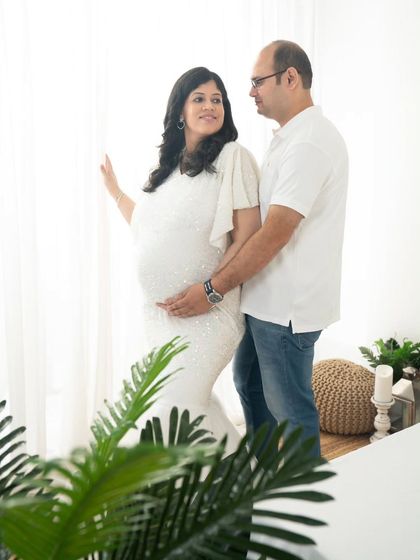 A quiet look shared between partners by the window. The natural light creates a soft and romantic mood, perfect for capturing the gentle moments of your pregnancy.