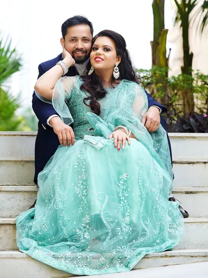 A lovely portrait of the couple seated on stairs, with the bride-to-be looking radiant in her sea-green lehenga.