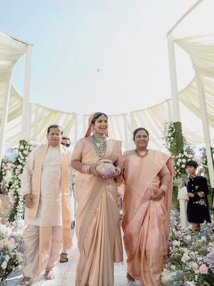 A beautiful family moment as the bride walks down the aisle, surrounded by the soft pastel florals that defined her wedding decor.