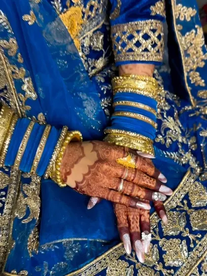 A close-up of the henna stain paired with beautiful blue and gold bangles. The deep color of the henna stands out wonderfully.