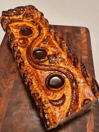 The top view of the Pâté En Croute, showcasing the intricate pastry work and the "chimneys" used to pour in the aspic. This is classical French charcuterie at its finest.
