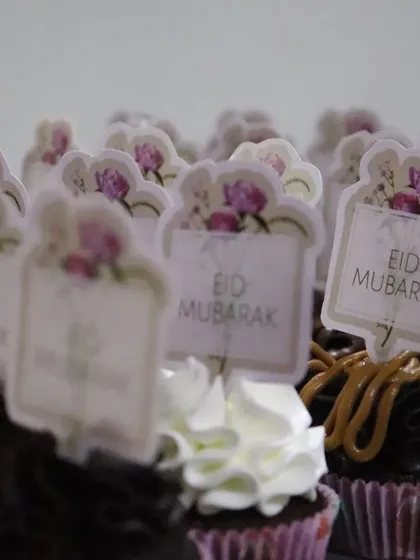 A mix of chocolate and vanilla frosted cupcakes ready for Eid, each with a custom topper.
