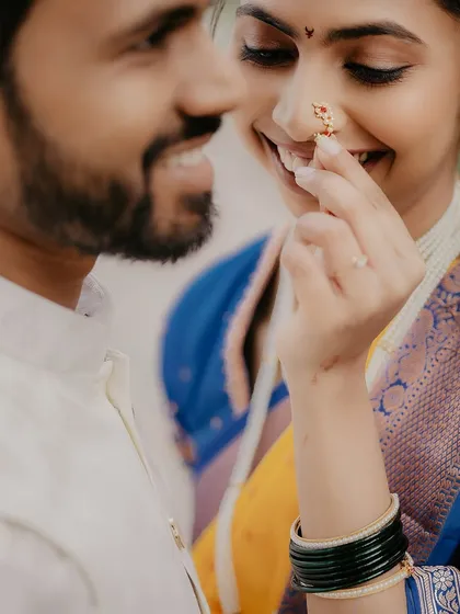 A tender close-up focusing on the bride's nose ring (nath), a classic detail in Maharashtrian bridal photography.