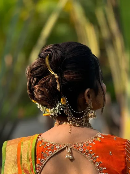 Another angle of the intricate Nauvari bridal bun, showing the placement of the layered accessories that cascade down from the bun, adding movement and grace.