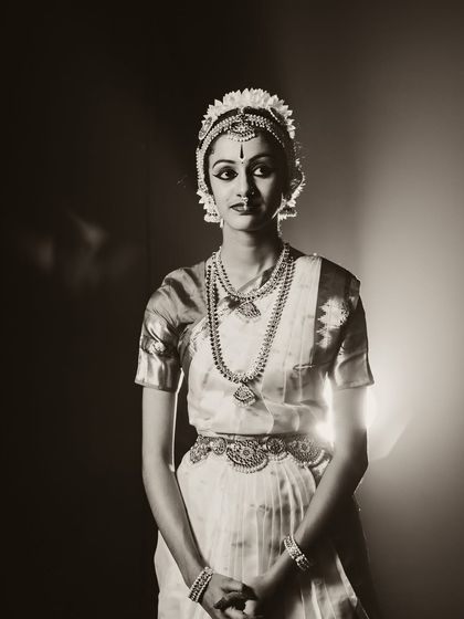 Another beautiful pose from a classical dance session. The lighting isolates the dancer, focusing on the intricate hand gestures and expressive eyes that are central to Indian classical dance.