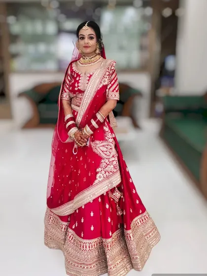 This bride's look is all about classic elegance. The makeup is clean and radiant, paired with a traditional red lehenga for her wedding day.