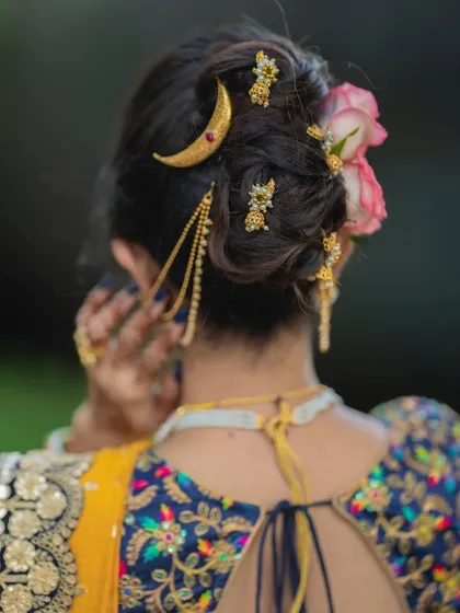 Bold tradition meets contemporary charm. This hairstyle, a messy khopa with modern accessories, is the perfect partner for an innovative drape like the saree-to-lehenga.