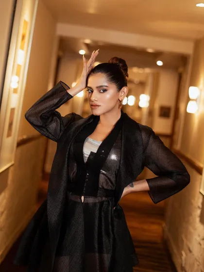 An expressive and artistic pose. The hand gesture adds a touch of drama and personality, making the image more than just a fashion shot.