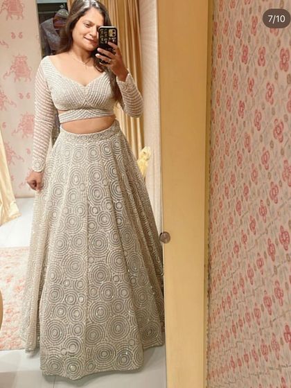 A client selfie showing off our stunning white lehenga with circular geometric embroidery. The full-sleeve, sheer top is both modern and elegant.