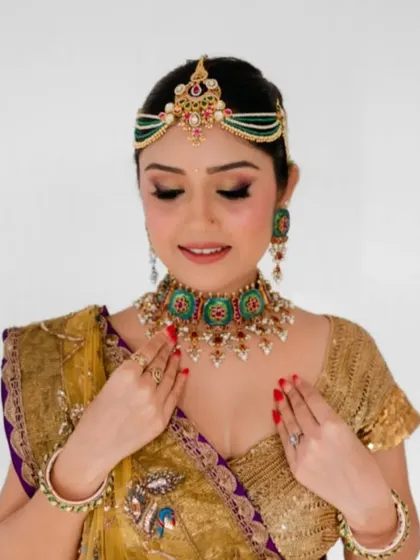 A beautiful shot of the client's makeup and the side of her floral bun. The colors of the hair accessories are chosen to match her outfit perfectly.