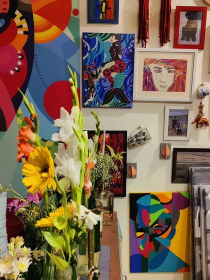 A gallery wall in my studio, a collage of my own work, art from friends, and personal photos.