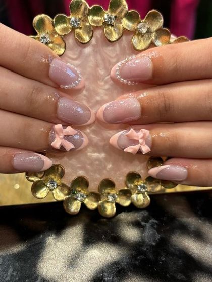 A subtle and sweet look with soft pink 3D bows on a neutral base with a delicate French outline. This shows how 3D elements can be understated and chic.