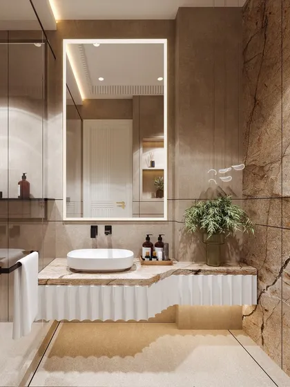 This bathroom visualization is a harmony of textures, from the rough, natural stone wall to the smooth, fluted vanity. The large, backlit mirror provides soft, functional lighting.