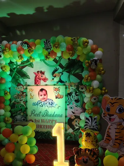 For kids' parties, themes are everything. Here is a jungle theme I did for a first birthday, complete with a personalized backdrop, animal cutouts, a full balloon arch, and a light-up number '1'.