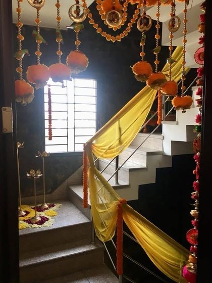 For a traditional 'kirtan' or prayer meeting, we use ethnic decor elements like these marigold garlands and pichwai-inspired fabric to create a serene and spiritual ambiance.