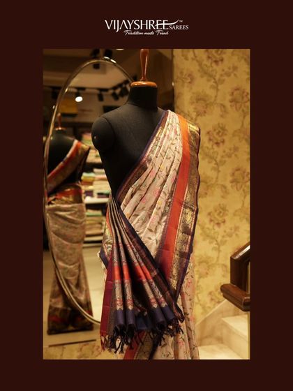 A soft drape Fusion Kanjivaram with intricate floral hand embroidery, styled on a mannequin to show its elegant fall.