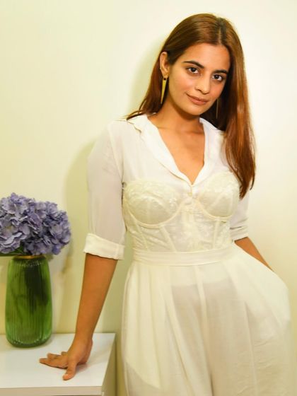 A clean, all-white look is so chic. Here I've layered a corset over a sheer white shirt and paired it with matching wide-leg pants for a sophisticated, monochromatic outfit.