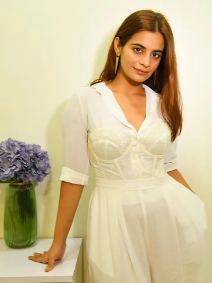 A clean, all-white look is so chic. Here I've layered a corset over a sheer white shirt and paired it with matching wide-leg pants for a sophisticated, monochromatic outfit.