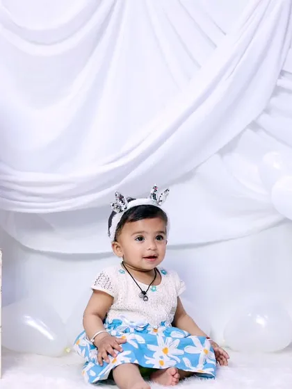 A simple and clean first birthday setup with 'ONE' blocks and a white-on-white theme.