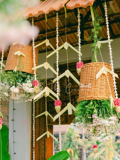 A detailed shot of the hanging decor, featuring woven baskets, delicate jasmine strings, and artistic palm leaf arrangements.