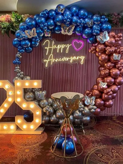 A beautiful ring setup for a 25th anniversary. We used chrome balloons in blue and rose gold, accented with butterfly details and a "Happy Anniversary" neon sign for a touch of romance.