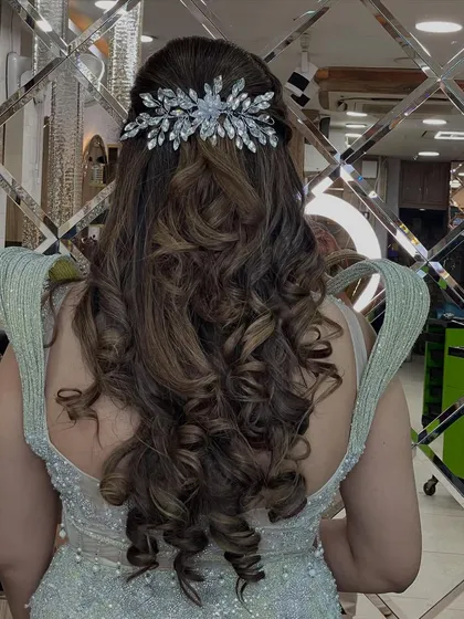 A view of the back of the hairstyle, featuring beautiful, cascading curls and an elegant crystal hair accessory.