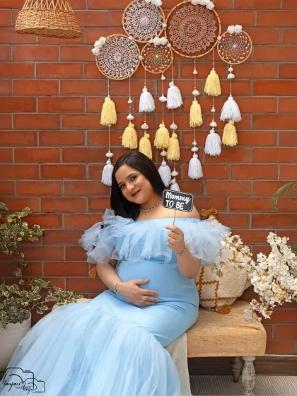 A beautiful solo portrait in the cozy corner. The "Mommy to Be" prop adds a sweet touch to this shot, celebrating her new identity.