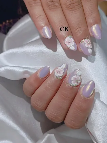 A different angle of the lavender chrome nails, showing how the light shifts on the chrome surface and highlights the 3D flowers.
