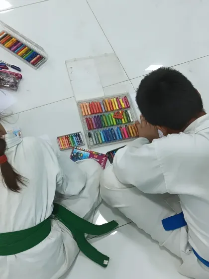 Two students sharing a box of crayons, working on their art side-by-side. These are the moments where friendships are built.