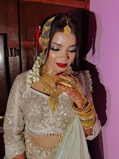 For this Nikaah bride, we went for a 'sheen glow' look. The makeup is luminous and ethereal, with silver-toned eyeshadow and a classic red lip.