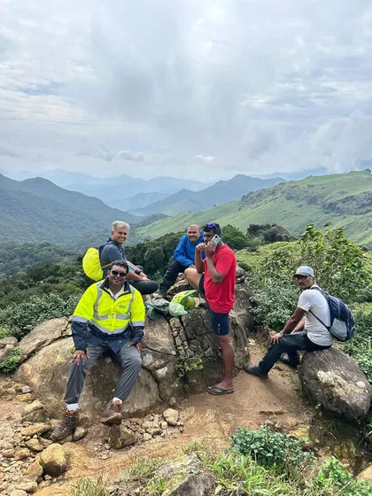Taking a well-deserved break at the summit of Thadiyandamol, enjoying the spectacular views of the surrounding hills.