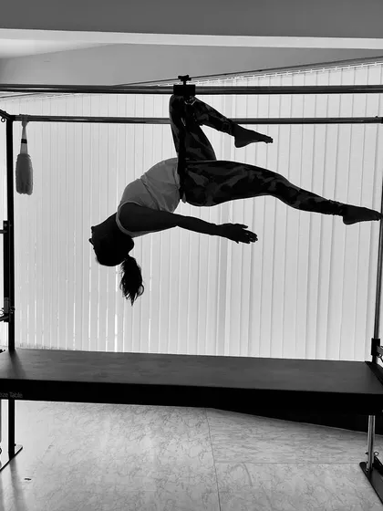A monochrome image of a client in a suspended pose, focusing on the beautiful lines and control of the movement.