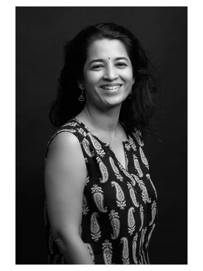 This black and white portrait showcases a confident and happy smile, with the simple lighting creating a beautiful and classic look.