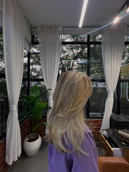 A wider shot of the color correction result, showing how the new color and style look in the natural light of the salon.