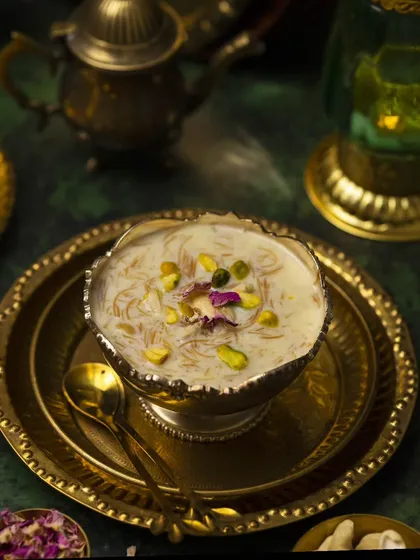 A wider shot of the Sheer Kurma, including traditional brass serveware. This adds cultural context and a sense of occasion to the photograph.