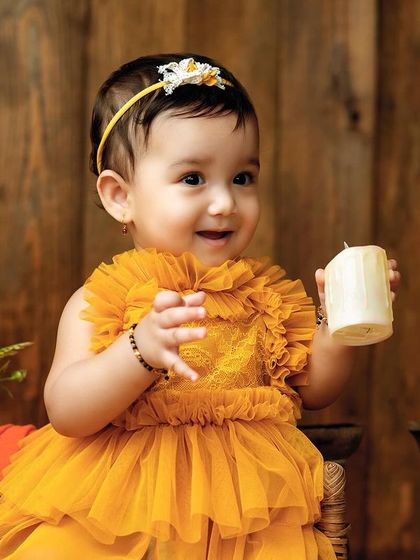 A close-up on that adorable face. The warm lighting and rustic props create a beautiful, classic baby portrait.