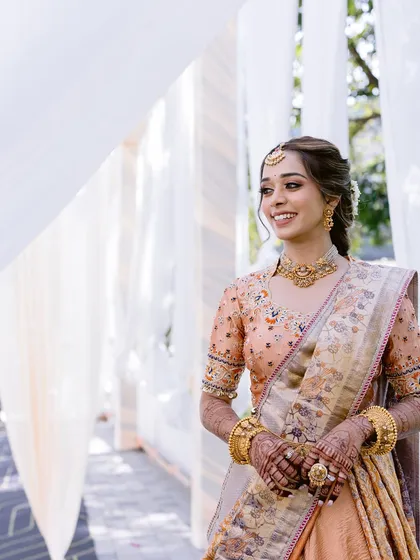 Another beautiful portrait through white drapes, capturing the bride's radiant smile and the soft, glowing makeup.
