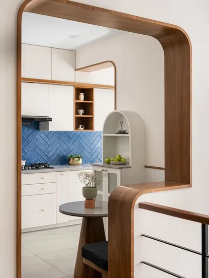 The beauty of our work is in the details. This curved wooden archway in the 'Palaash' kitchen is a signature element, softening the lines of the space and showcasing our craftsmanship in creating fluid, harmonious transitions between rooms.