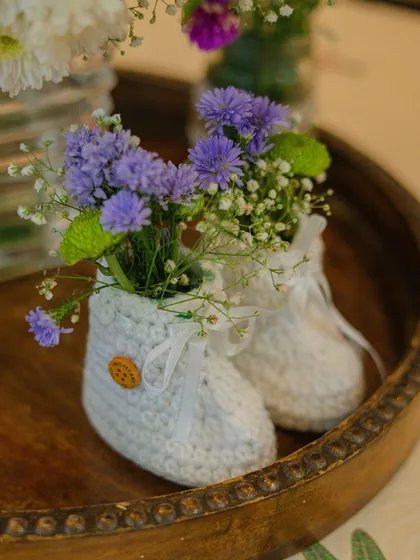 It’s the little things that bring the most joy. ❤️ As a unique centerpiece idea, I used these adorable crocheted baby booties as miniature vases for delicate flowers. This is the kind of personal, creative touch I bring to every event.