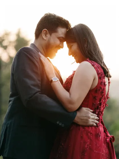 A backlit portrait at sunset, creating a beautiful, warm flare that envelops the couple in a romantic glow during their scenic pre-wedding shoot.
